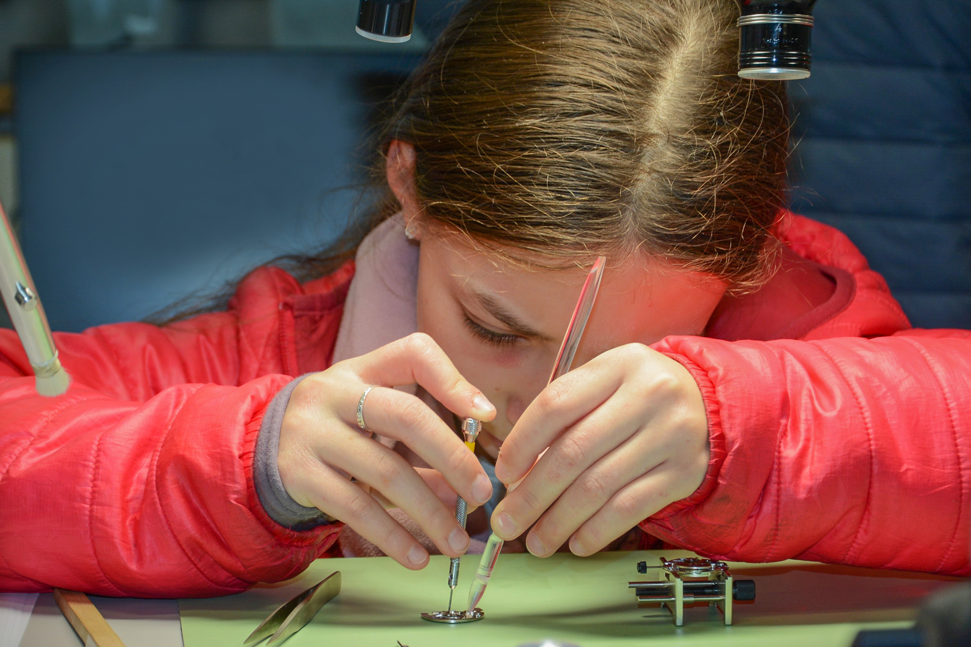 : Mädchen arbeitet an einem Uhrwerk